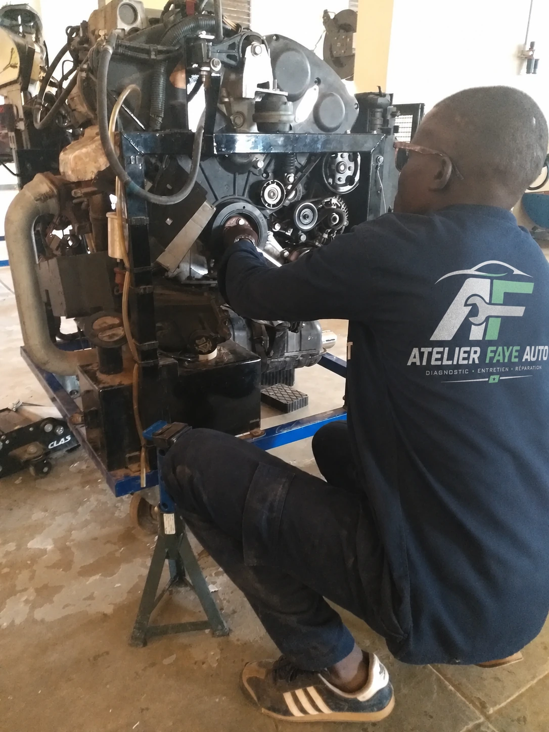 Matta Faye en intervention sur un moteur, Atelier Faye Auto à Dakar